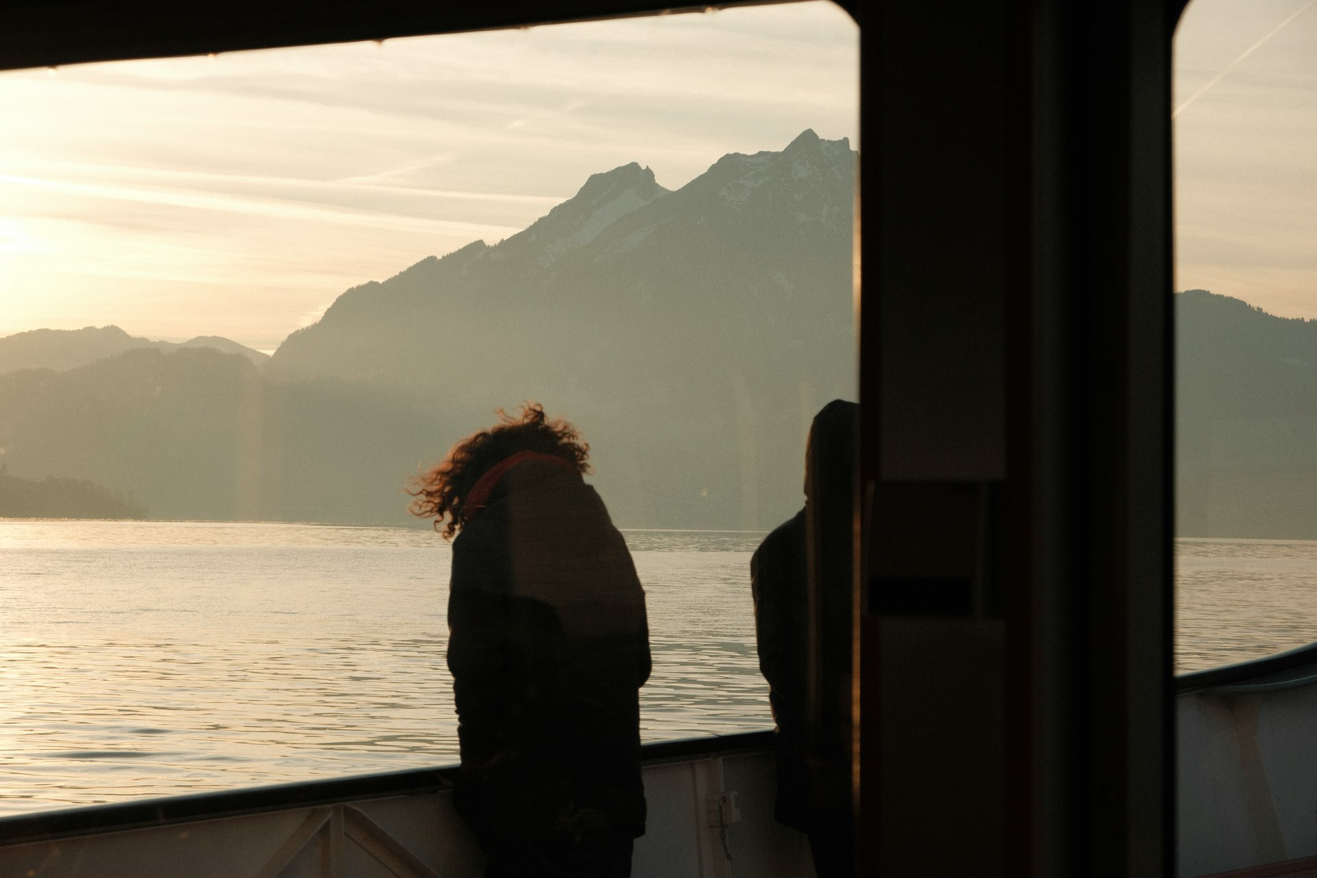 Two people on a boat with mountains in background